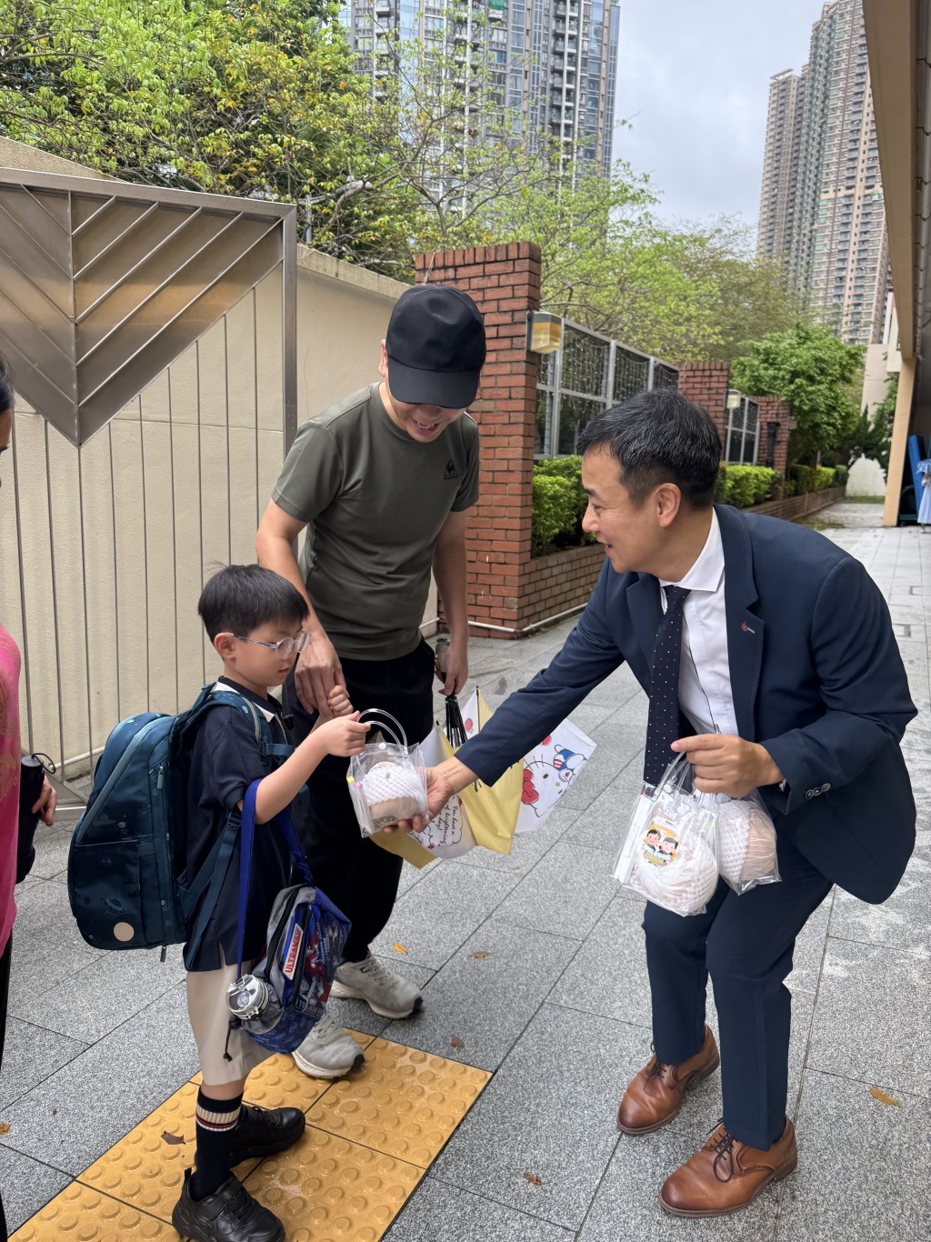 将军澳循道卫理小学校长林德育(右)与老师于开学日清晨在校门迎接学生,并亲自送上寓意「欢迎您」的「欢迎梨」及迎新礼包。(图片来源:Oh!爸妈) 将军澳循道卫理小学校长林德育(右)与老师于开学日清晨在校门迎接学生,并亲自送上寓意「欢迎您」的「欢迎梨」及迎新礼包。(图片来源:Oh!爸妈)