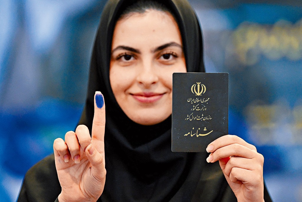 一名伊朗女选民在伊朗驻科威特使馆为总统选举投票后，展示有墨水标记的手指。