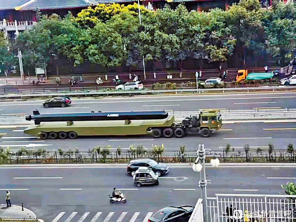 大型黑色無人水下航行器在平板平台上運輸。