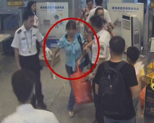 女子不願讓安檢人員檢查大型行李。