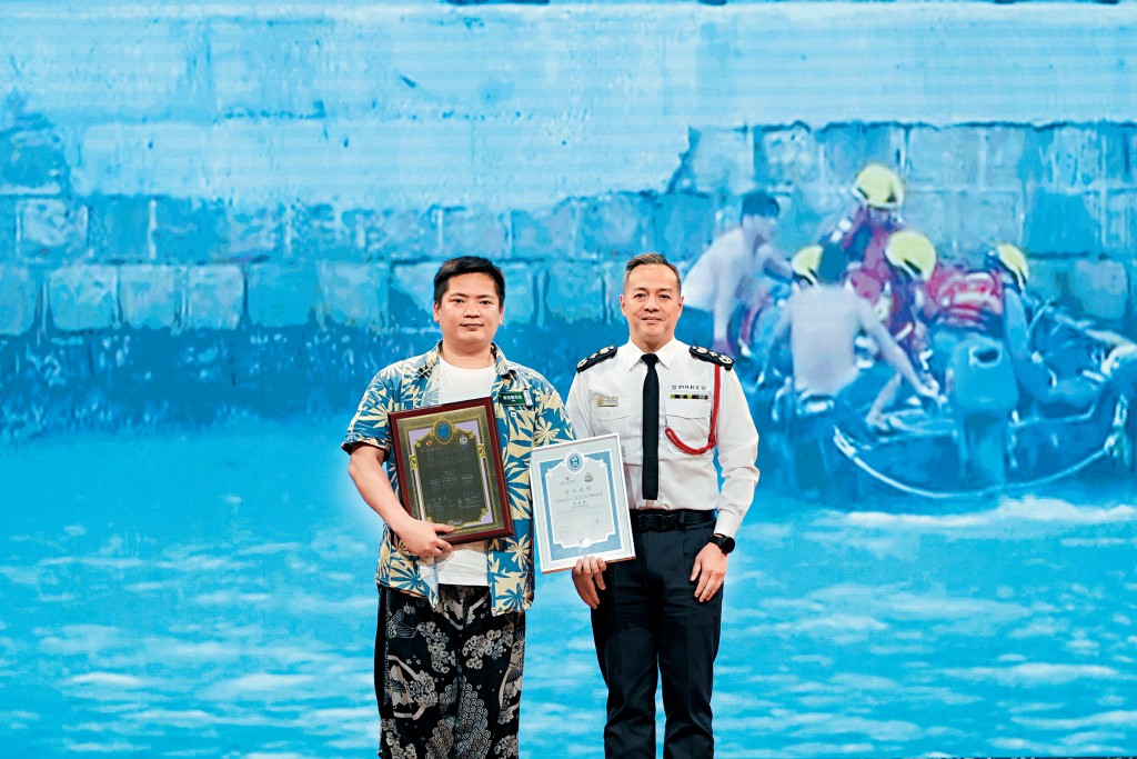 警務處處長周一鳴（右）頒發「全年好市民獎」予在去年超強颱風「樺加沙」吹襲香港期間，勇救三名墮海遇溺者的梁浩賢。