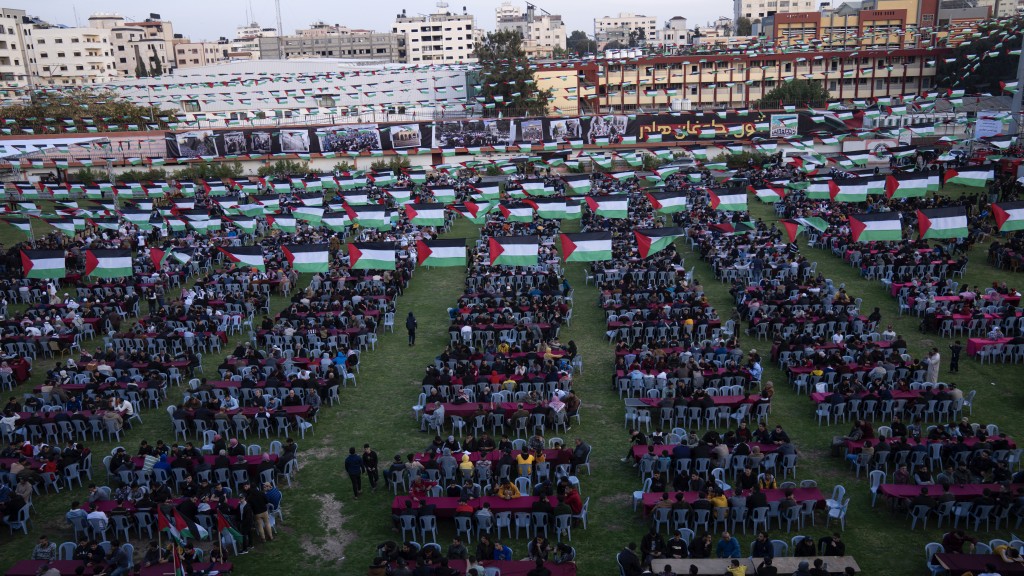 加沙的巴勒斯坦人在庆祝2023年圣城日的活动上，观看伊朗总统莱希预录讲话。 美联社