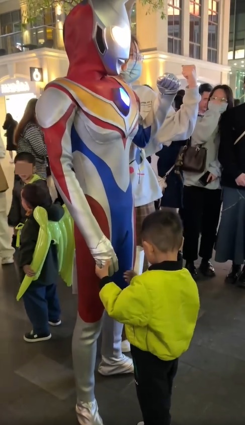 一位小童上前与超人握手。网上截图