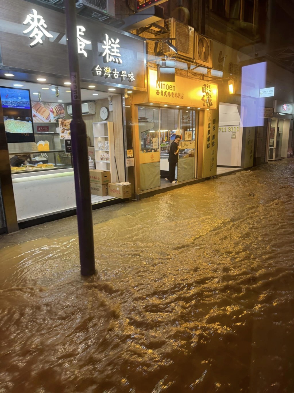 大量黃泥水幾乎湧入馬路兩旁的店舖。網上圖片