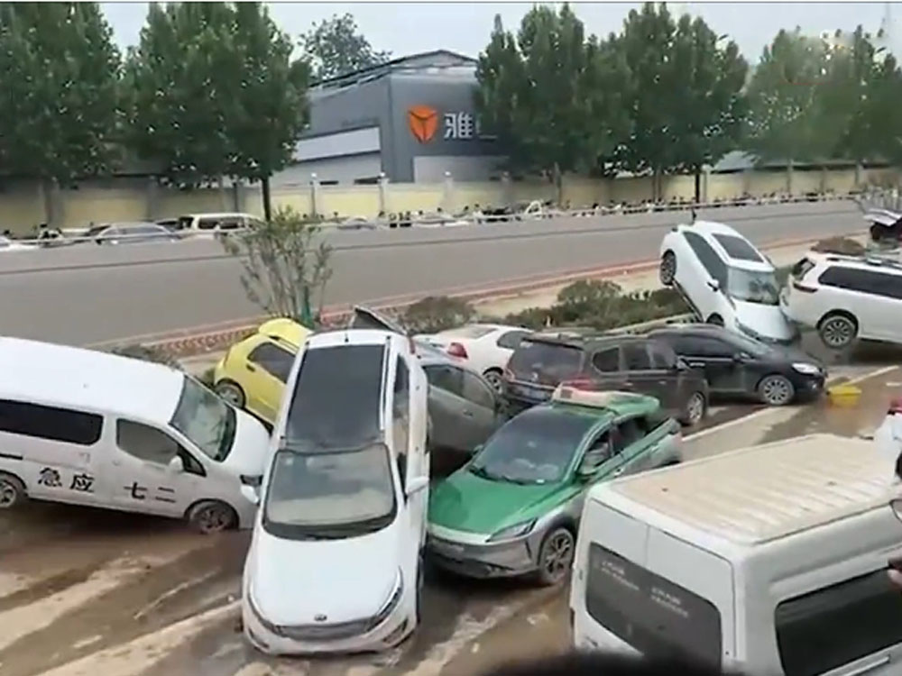 幾十輛車被洪水沖至堆疊在隧道口附近。