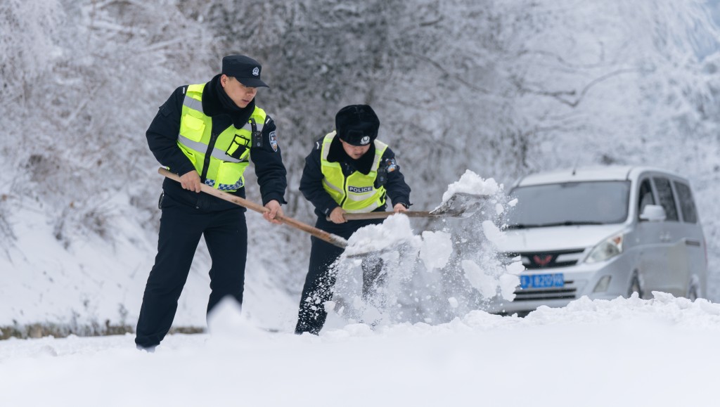 警察搶通被暴雪封堵的的公路。