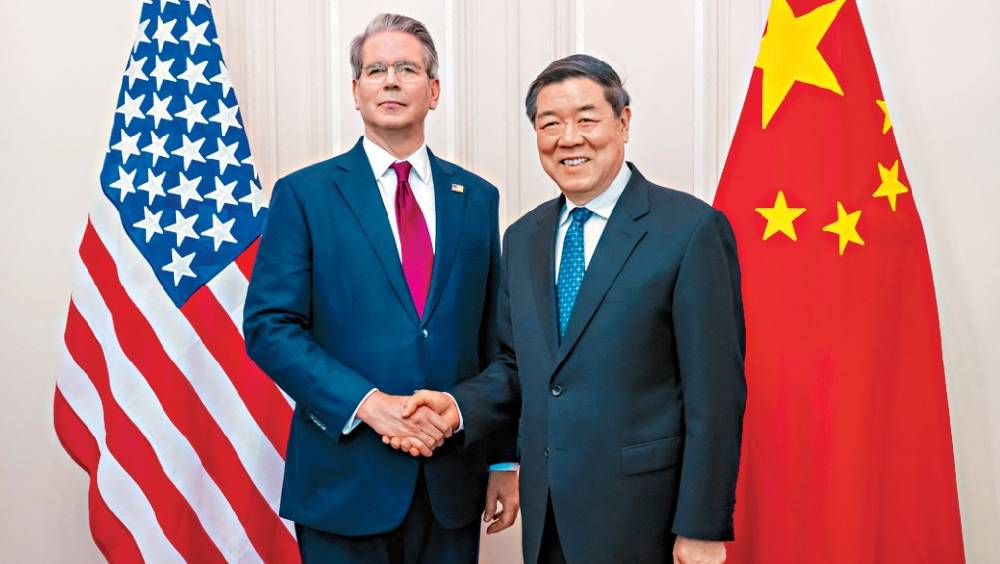 去年10月，美國財長貝森特與中國副總理何立峰握手。 路透社
