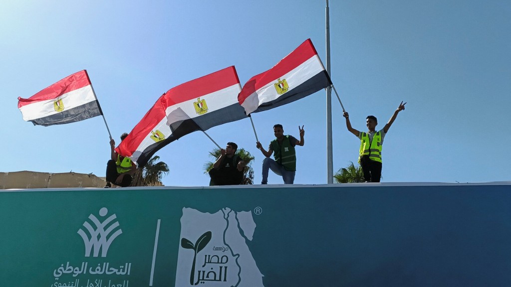 卡車上的埃及人揮舞國旗。路透社
