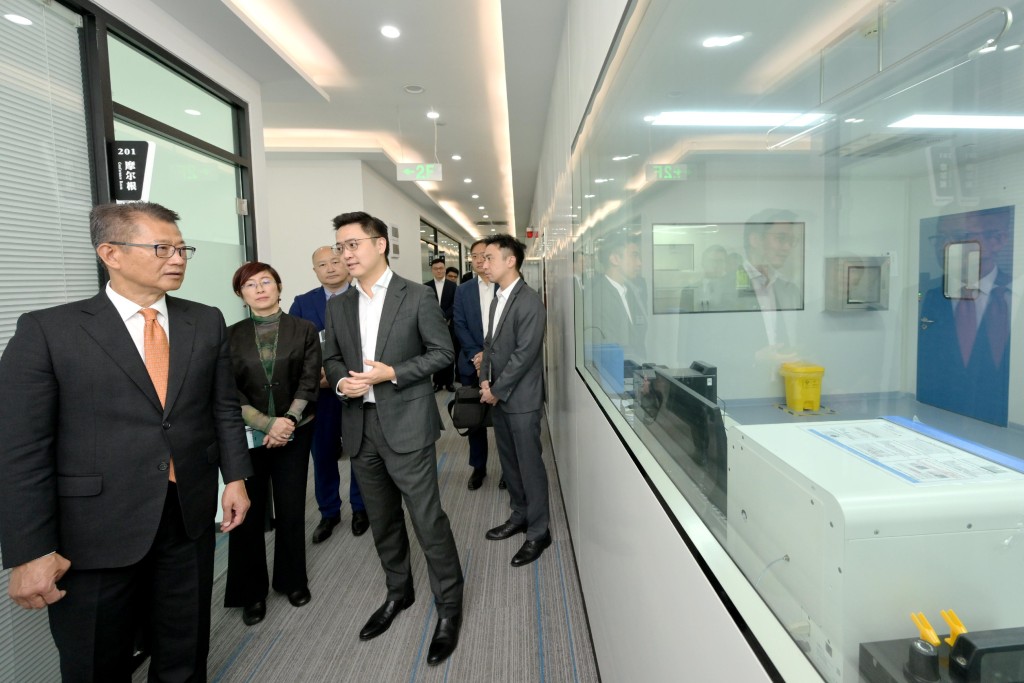 陳茂波（左一）到訪一家從事生物醫藥科技的科創企業。政府新聞處