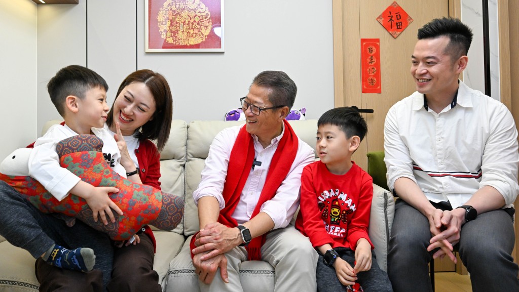 財政司司司長陳茂波（中）探訪居於西環的家庭，與他們親切交流，送上新春祝福。政府新聞處
