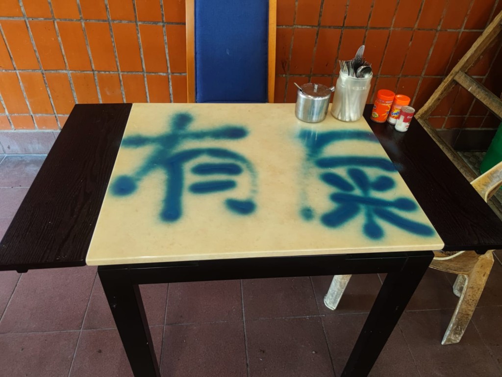 熟食檔的部分餐桌及圍欄遭人噴大字。 梁國峰攝