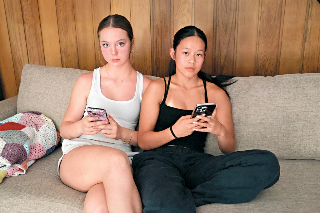 悉尼兩名14歲的女孩在玩手機。 