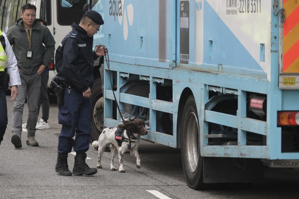 警员带同警犬在现场逐一为进入法庭的车辆进行安检。陈浩元摄