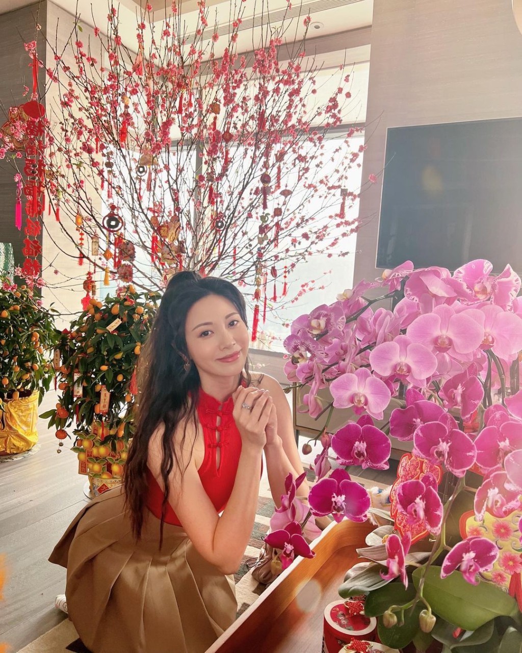 昨日（25日）朱晨麗於IG分享靚相，身穿紅色入肩中式設計背心的她跪拜賀新年，旁邊擺放的鮮花都不及她搶眼，可謂人比花嬌。