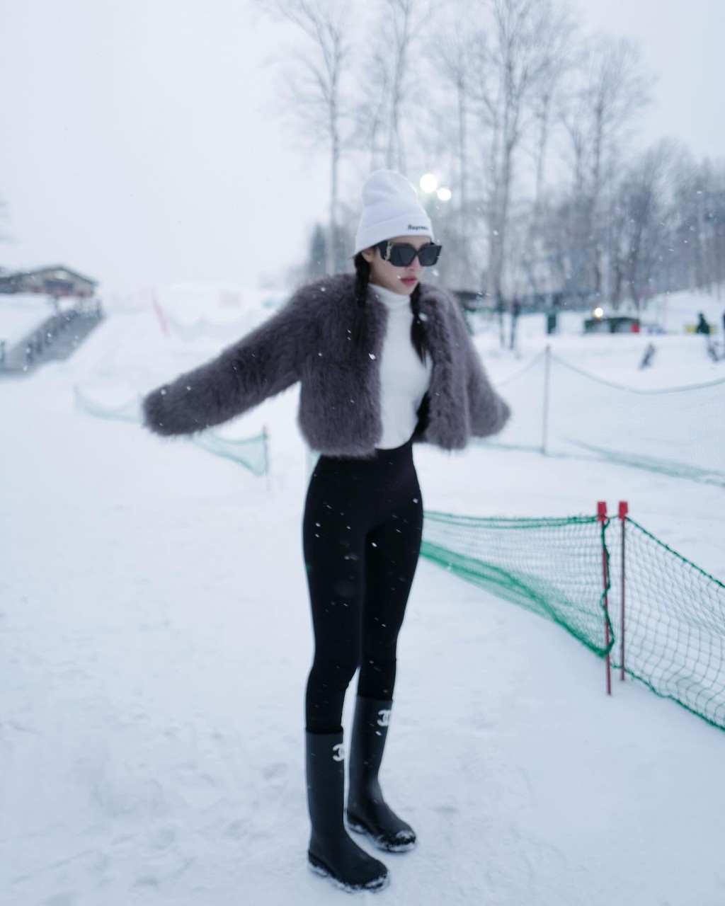 蔚雨芯站在雪地，穿上Chanel 双 C logo 中筒长靴。