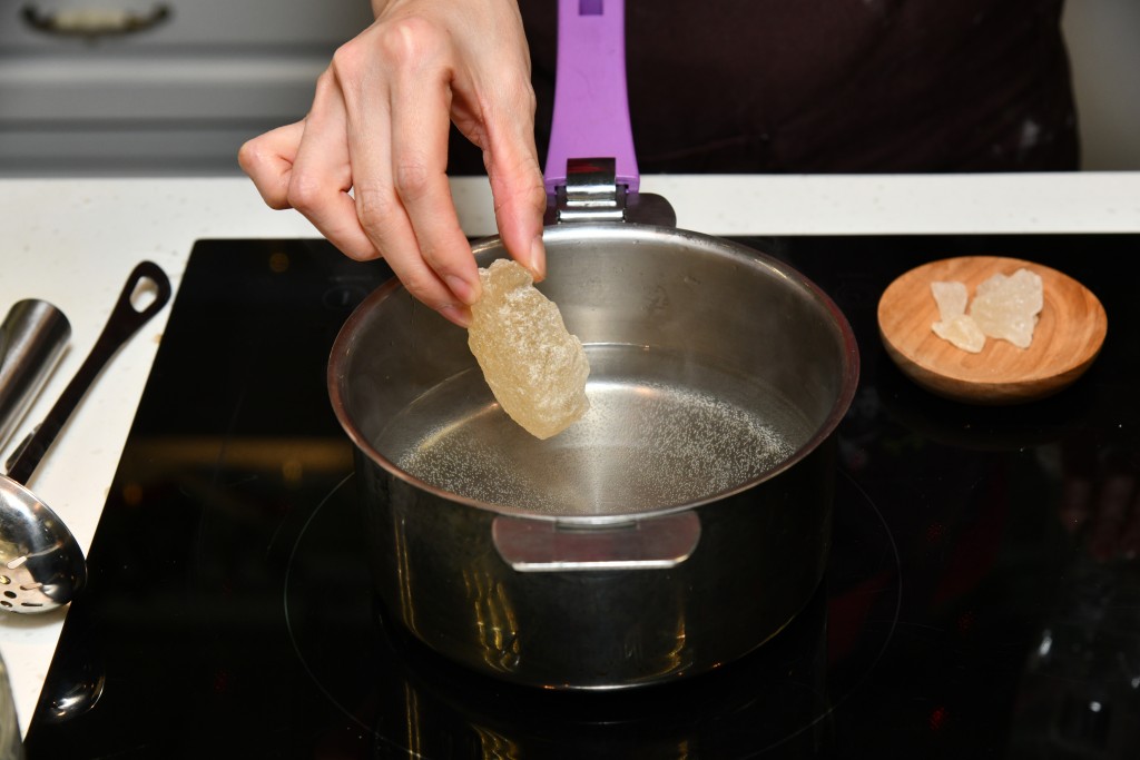 Step 3: 煲滾水，加入桃膠和冰糖，煮至冰糖融解。Bring the water to a boil, add the peach gum and rock sugar, cook until the rock sugar dissolves completely.
