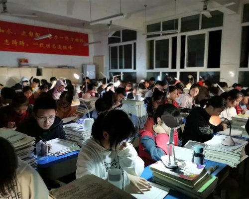 四川一所中學學生停電下自備枱燈繼續溫習。網圖