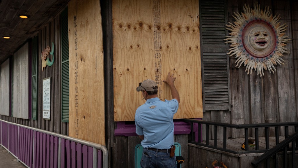 佛州锡达礁商户给店舖围木板挡风。 路透社