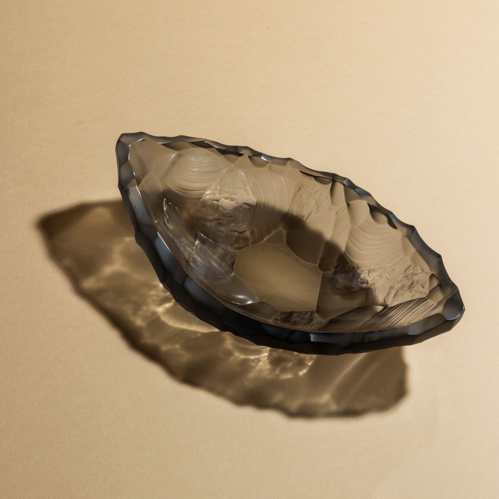 Lalique「西勒克斯」 灰色 水晶小號盤子，表面的 雕刻紋理呈現礦物形態 的原始美。（$7,800）