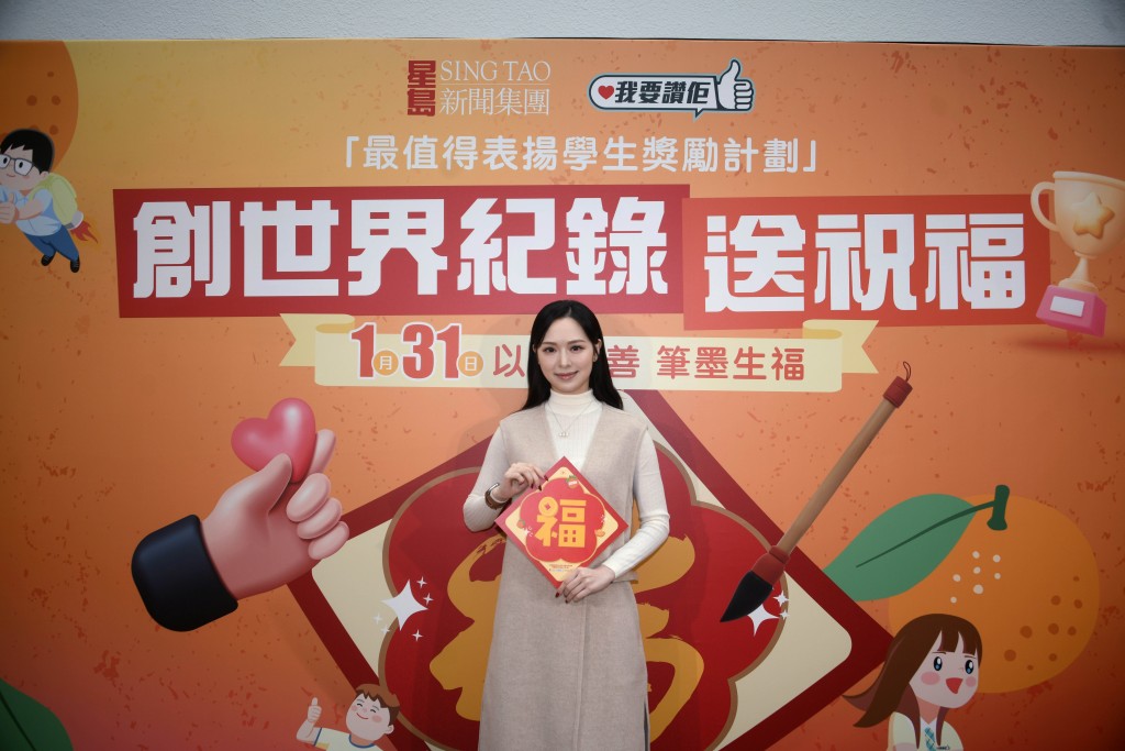 活動主持馮盈盈展示由華潤慈善基金贊助的揮春，學生撰寫的福字作品將印製成揮春派發。