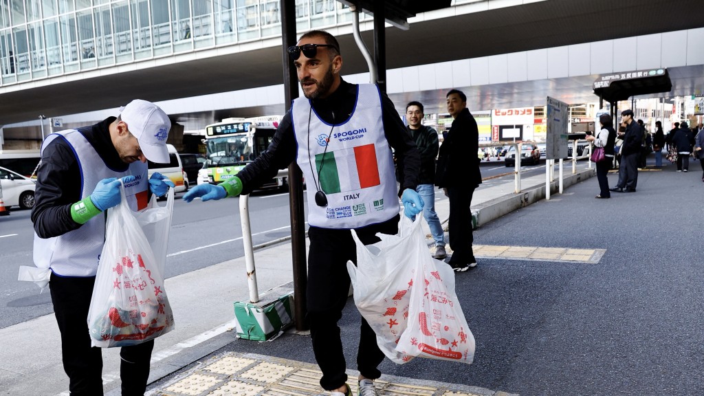 意大利队的成员在街头寻找垃圾。 路透社
