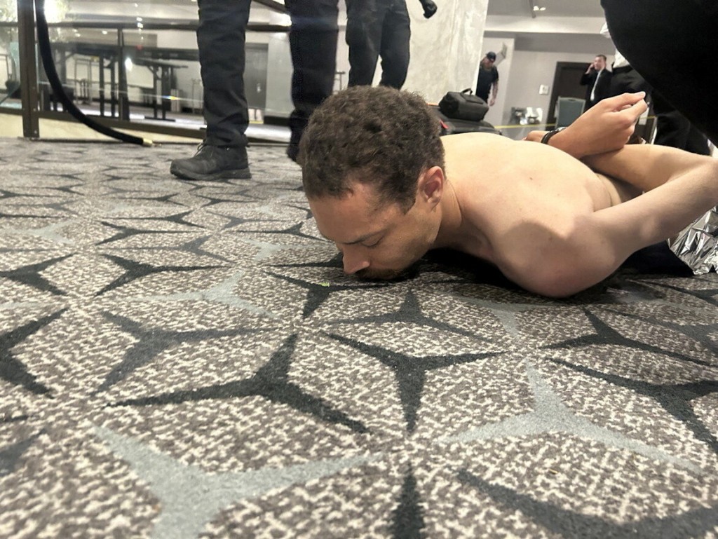 白宫记者协会晚宴枪击案嫌疑人艾伦被执法人员拘留后躺在地板上。 路透社