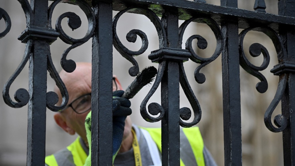 英王查理斯三世的加冕典礼在即，工人补油粉饰白金汉宫围栏。 路透社