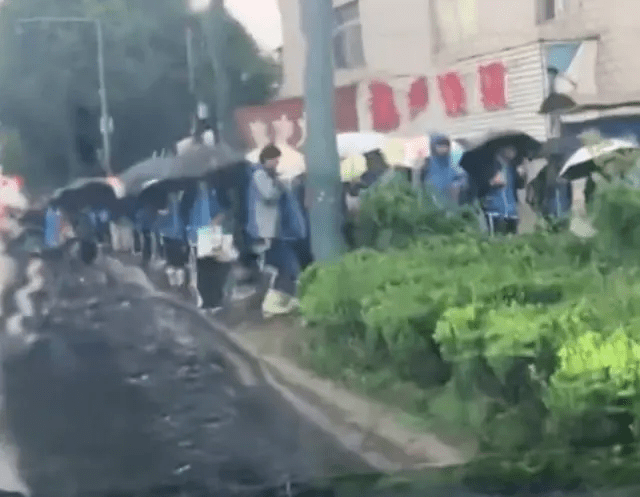  网片显示，江苏常州一所学校外，有大量学生在淋雨等开门。