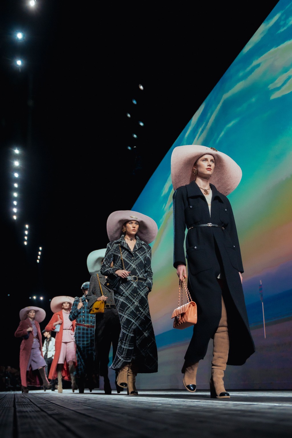 Chanel的时装骚场重塑杜维埃海滨长廊，模特儿配合电影感的造型徐徐步出，散发昔日风华。