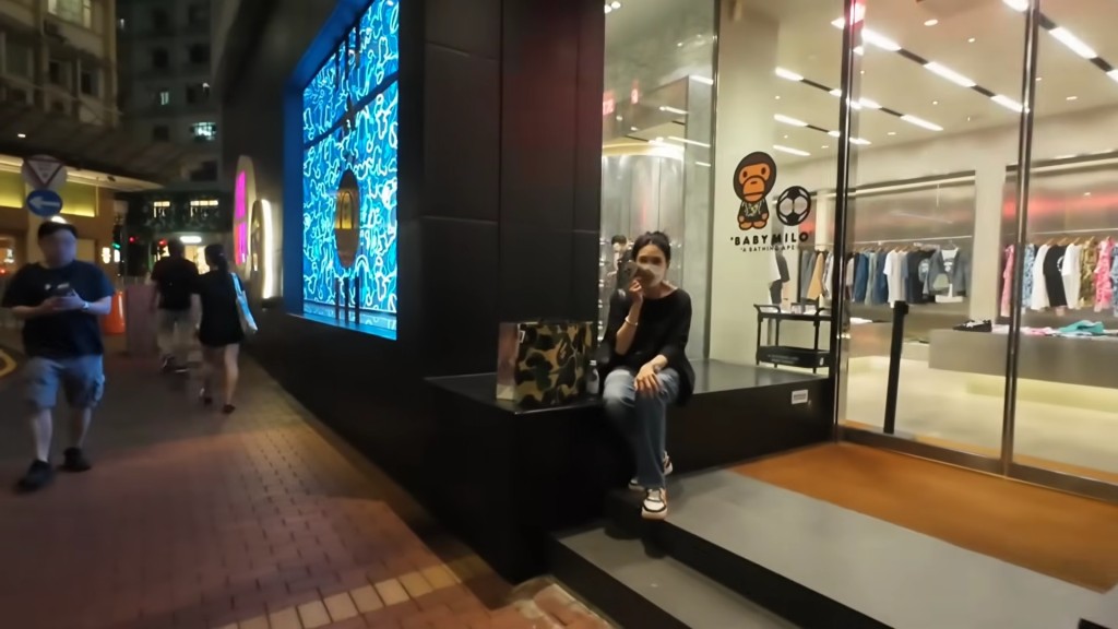 邱淑貞坐在店舖外講電話。(YouTube@SAMSAM週街走) 邱淑貞坐在店舖外講電話。(YouTube@SAMSAM週街走)