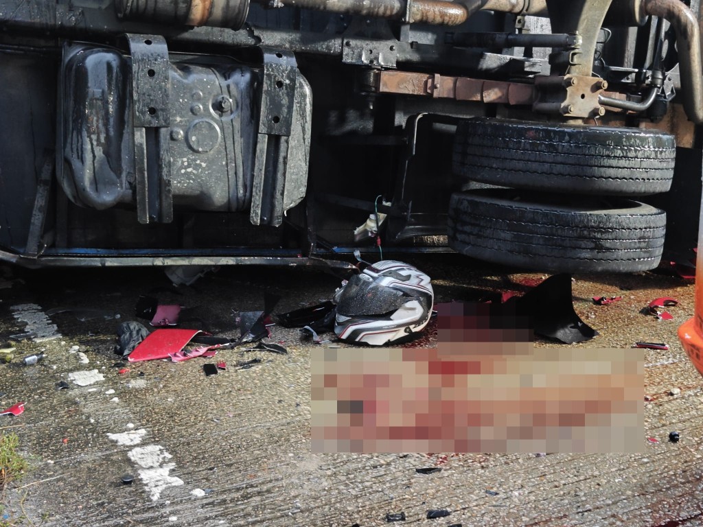 密斗貨車前面遺下一頂電單車頭盔並有其他電單車碎件，地上滿是血迹。黎志偉攝