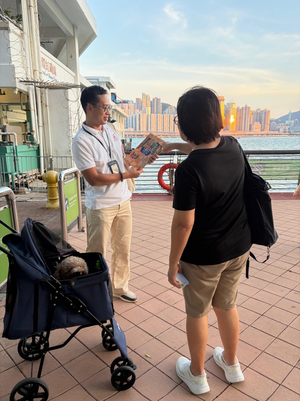 食環署人員向狗主派發宣傳單張,提醒他們攜狗外出用膳時須守法依規。政府新聞處圖片 食環署人員向狗主派發宣傳單張,提醒他們攜狗外出用膳時須守法依規。政府新聞處圖片