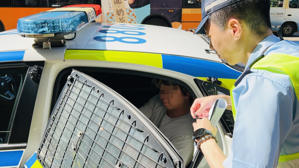 警员将司机带上警车。