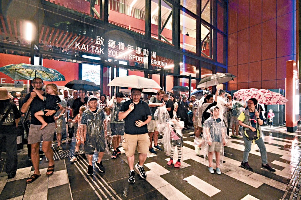 散場時沒帶雨傘的觀眾穿上園方派發的即棄雨衣，順利離開場館。