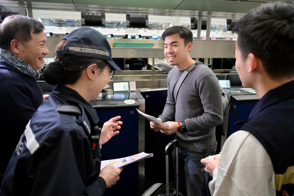 警方夥入境處員工於機場向出發往柬埔寨、泰國等東南亞國家旅客派防騙傳單，提醒市民提高警惕，提防誤墮騙局。蘇正謙攝