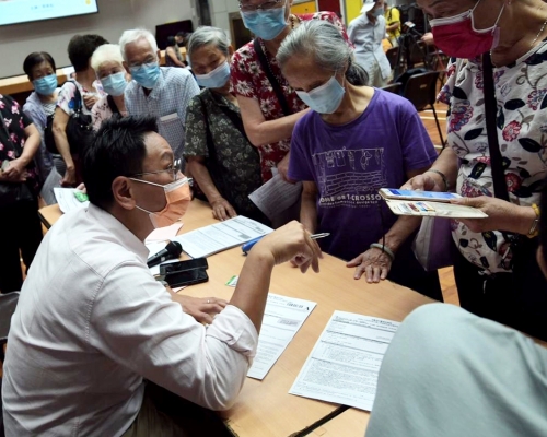  工聯會九龍東總幹事鄧家彪(左)指政府低估市民登記消費券的踴躍程度。