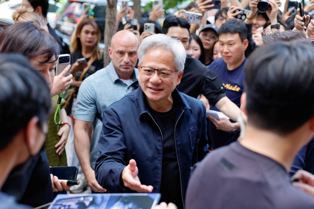黃仁勛在韓國首爾一間網吧前與粉絲互動。路透社