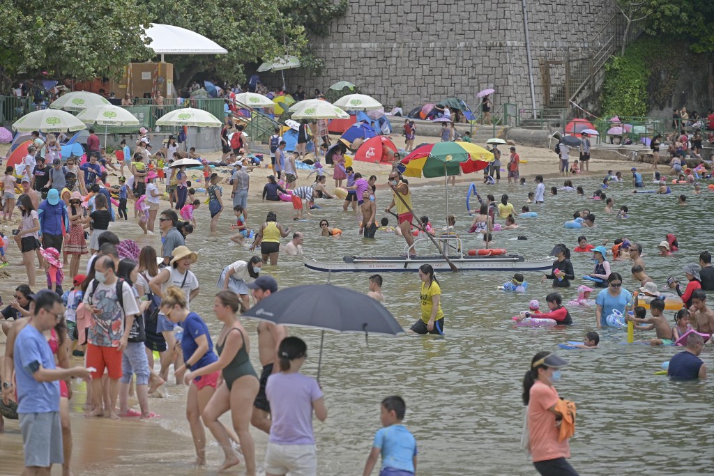 跟着龙舟游泳成为了节日习俗，每逢端午沙滩都人山人海。资料图片