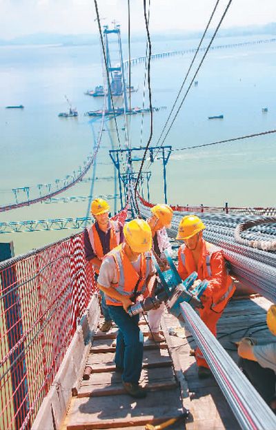 深中通道伶仃洋大橋建設者在架設主纜索股。