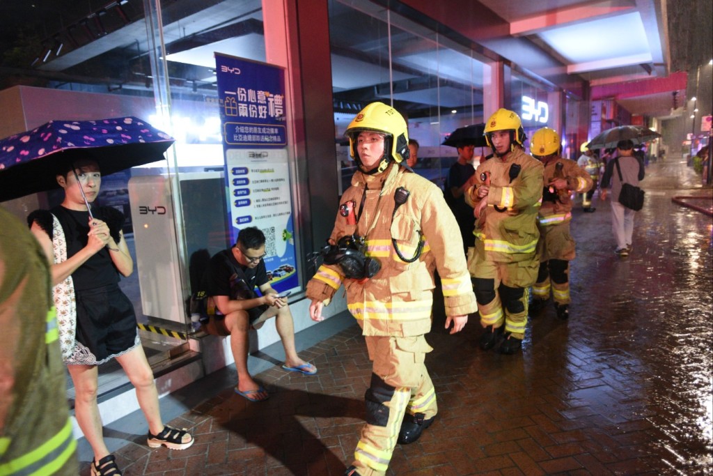 有商户需要冒雨疏散逃生。尹敬堂摄