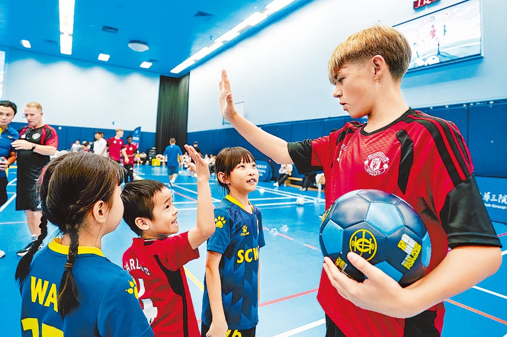 曼聯青年球員與本地小學生一齊踢波。