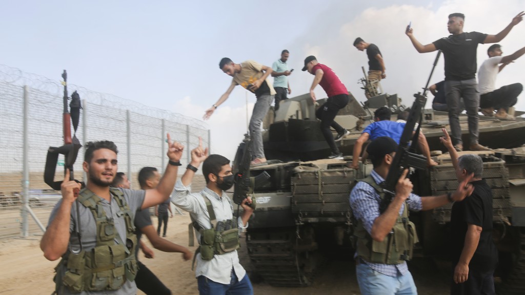 哈馬斯突襲以色列當天，成員舉槍慶祝奪取一輛以色列坦克。 美聯社