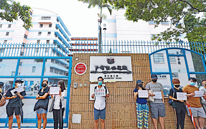 中华基金中学昨门外有人手持标语默站，抗议校方打压罢课，校徽亦被涂污。