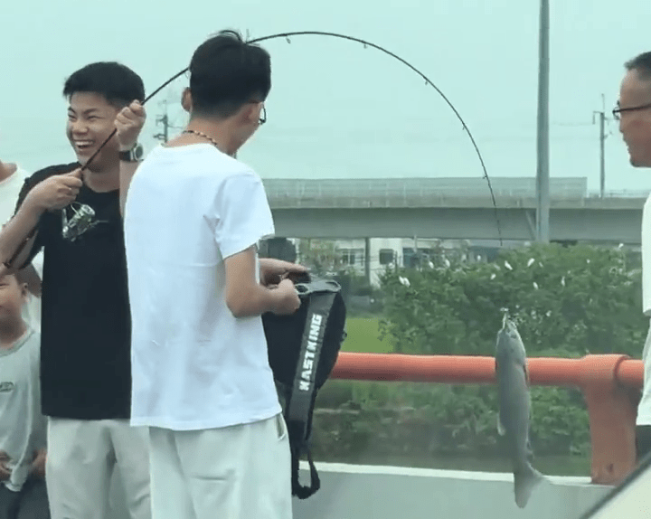 塞車塞出鬆弛感，車主落車釣魚「一擊即中」，笑逐顏開。