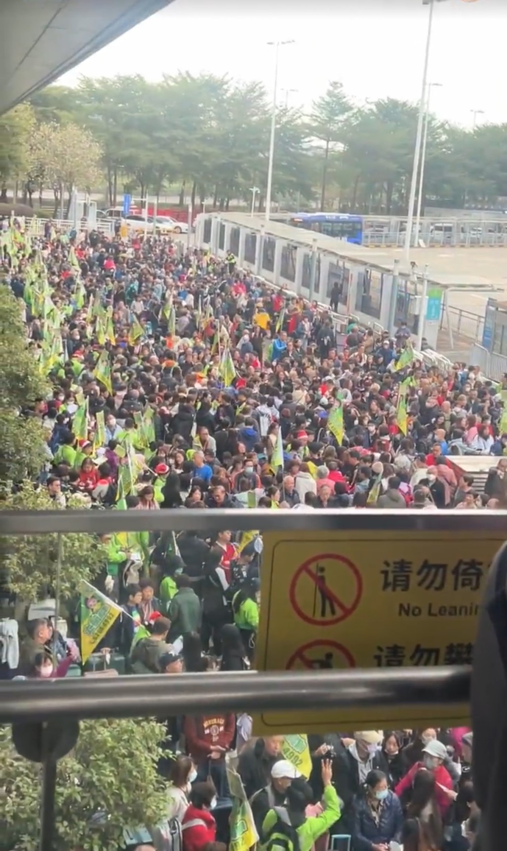 多名導遊舉起旅行團「旗仔」或標識，組織成員排隊集合。