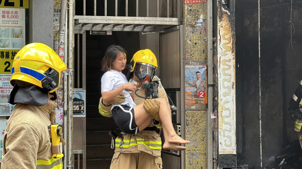 消防員抱起赤腳女子逃生。梁國峰攝