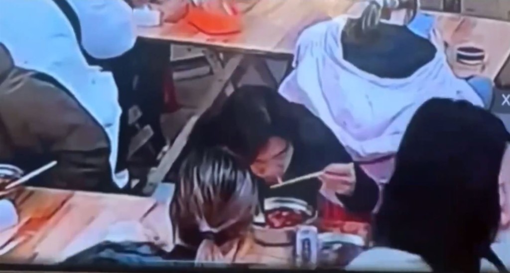 缺德黑衣女將螺螄粉湯倒入背座的羽絨衣帽內。