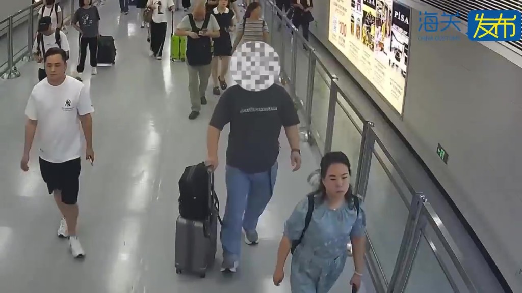 涉事男性旅客（身穿牛仔裤，拖行李箱者）。
