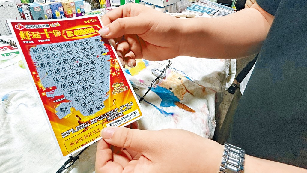 北京年轻人展示中奖的刮刮乐彩票。