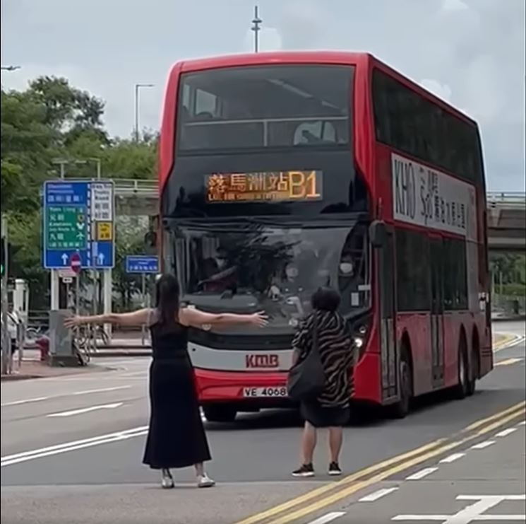 黑裙女擋在巴士前。網上影片截圖